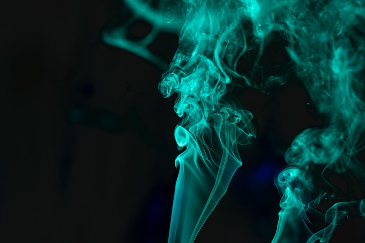 Volutas de humo turquesa sobre fondo negro