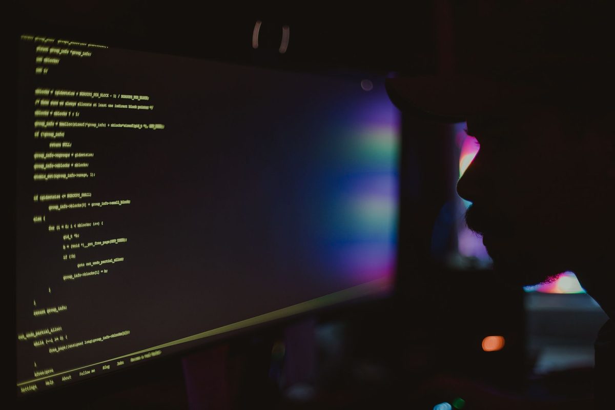 Pantalla con código brillando en una habitación oscura