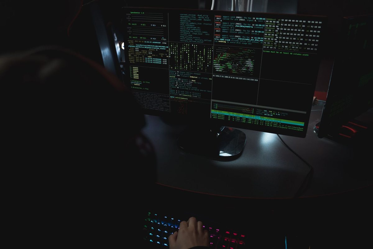 Puesto de trabajo con varios monitores en una sala a oscuras