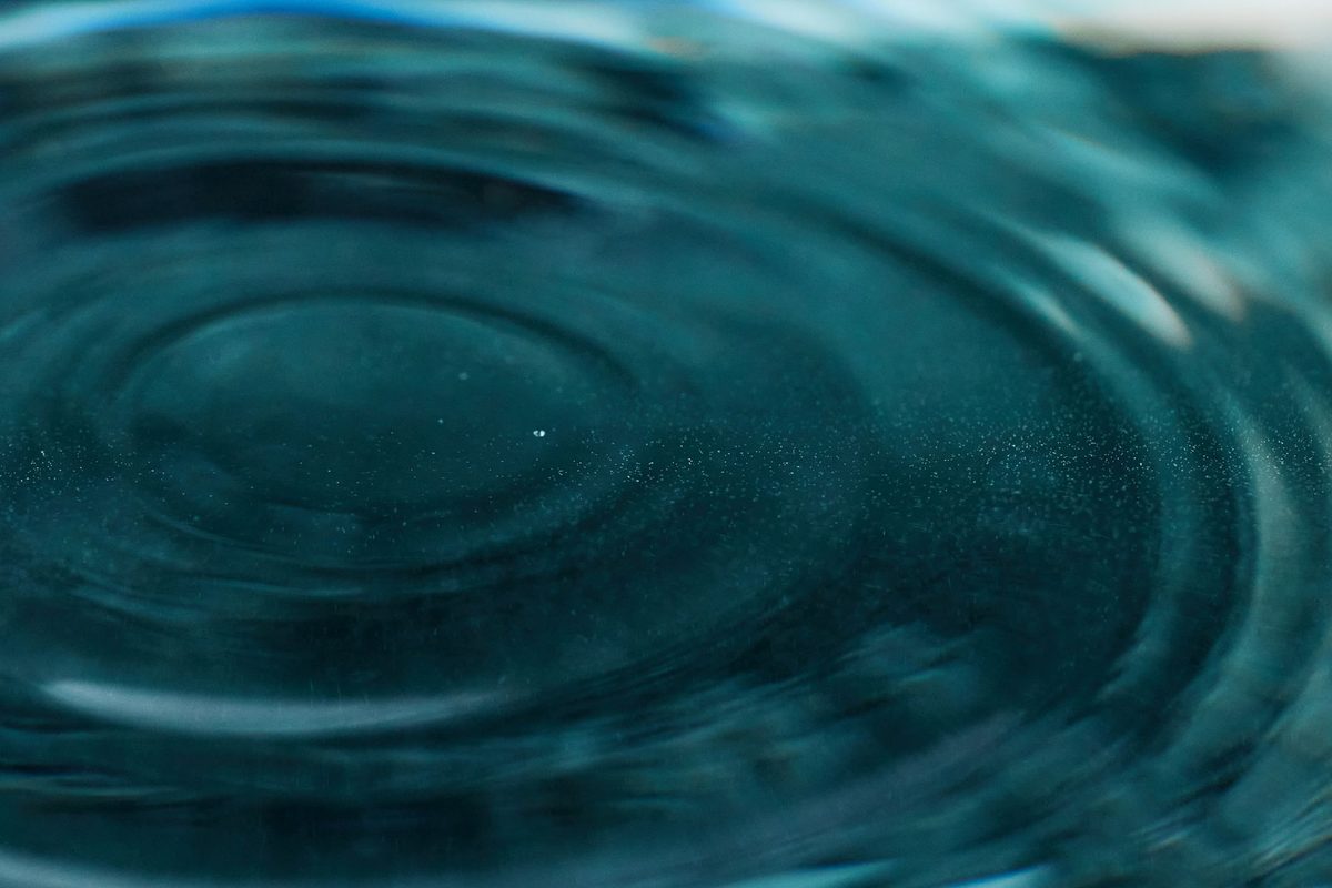 Ondas concéntricas sobre agua turquesa