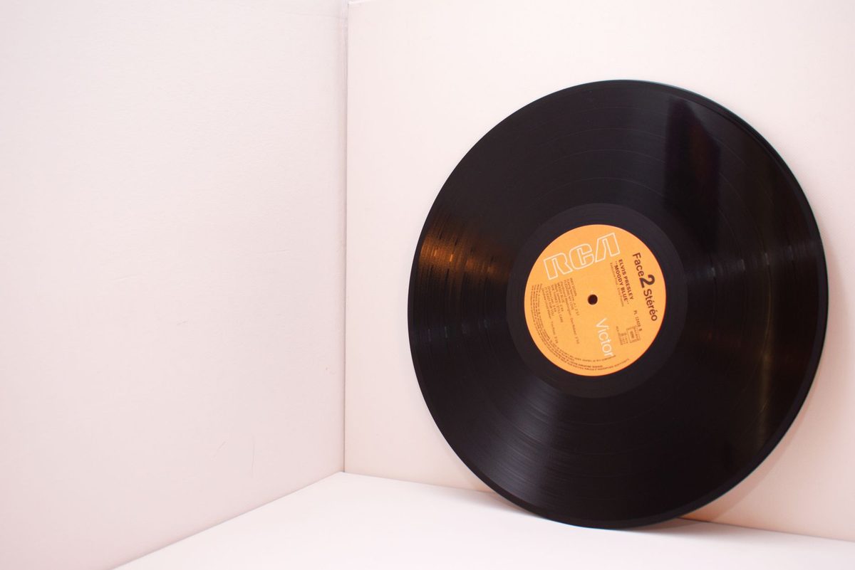 Vinilo negro apoyado en la esquina de una pared blanca