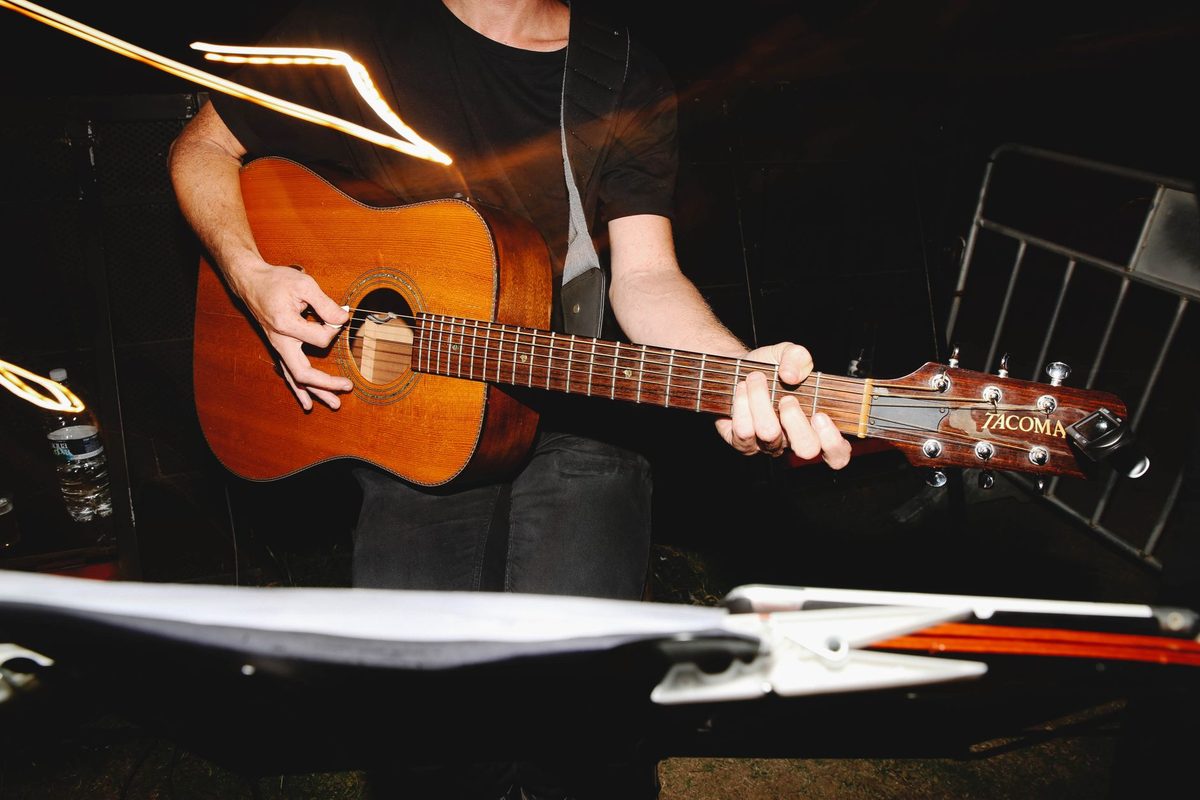 Guitarrista tocando en vivo con luz cálida