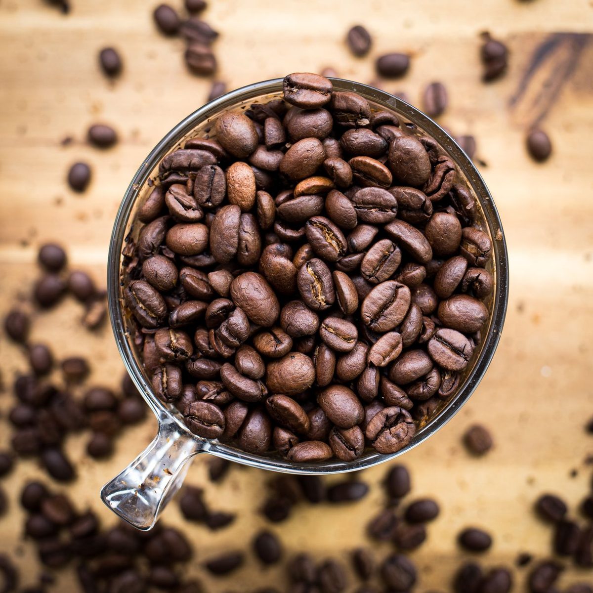 Taza llena de granos de café tostado