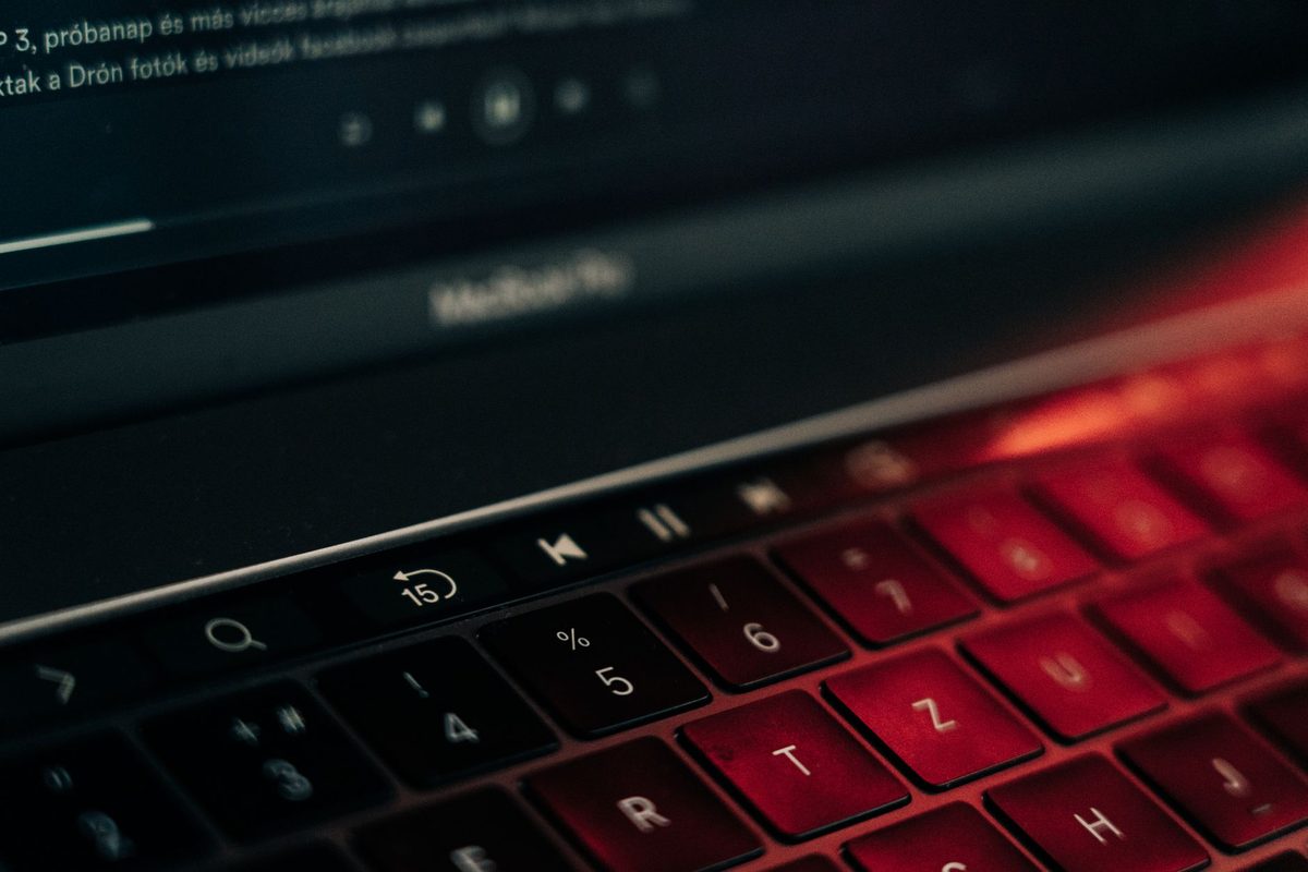 Teclado de una laptop con reflejos rojos